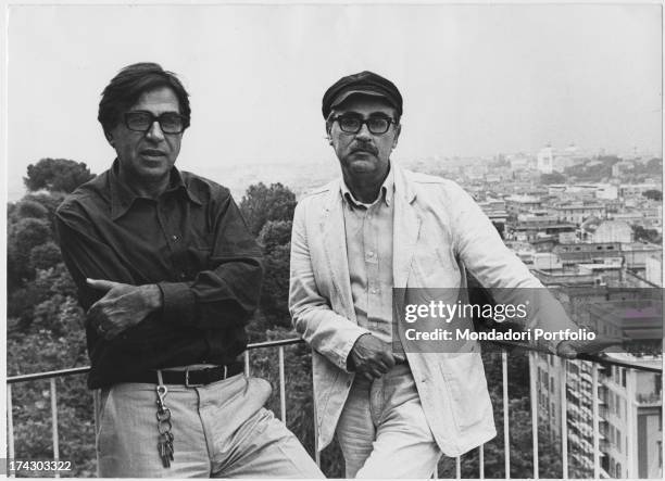 The directors Paolo Taviani and Vittorio Taviani, posing on a balcony; in the background a view of the city. Rome , 1982..