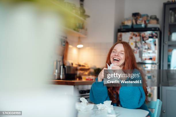 happy sick woman with facial tissues sitting at table - funny facial hair stock pictures, royalty-free photos & images