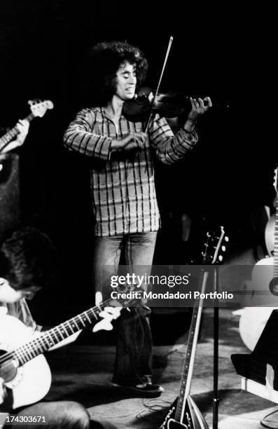 The Italian singer-songwriter Angelo Branduardi plays the violin standing on stage during a performance. Italy, 1977..