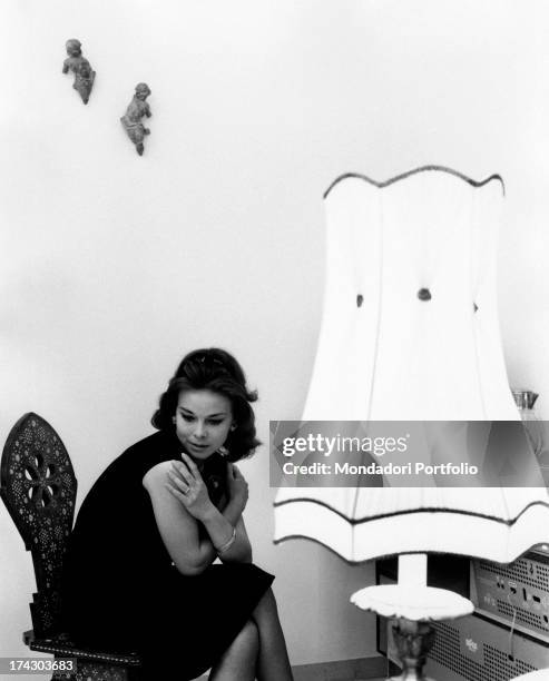 The Italian actress Gabriella Pallotta poses for the photographer while sitting on the sofa in the living room of her Roman house. Rome , 1964..