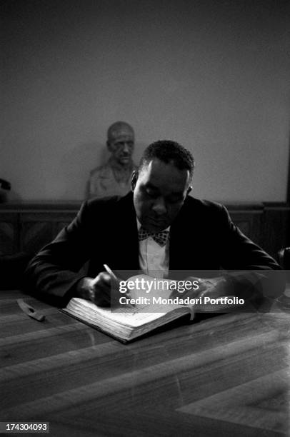 American writer Richard Wright sitting at a desk and making notes during a press conference. Richard Wright is visiting Italy for the publication of...