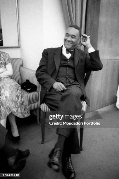 American writer Richard Wright smoking a cigarette and smiling. Richard Wright is visiting Italy for the publication of the book Black power. Milan,...