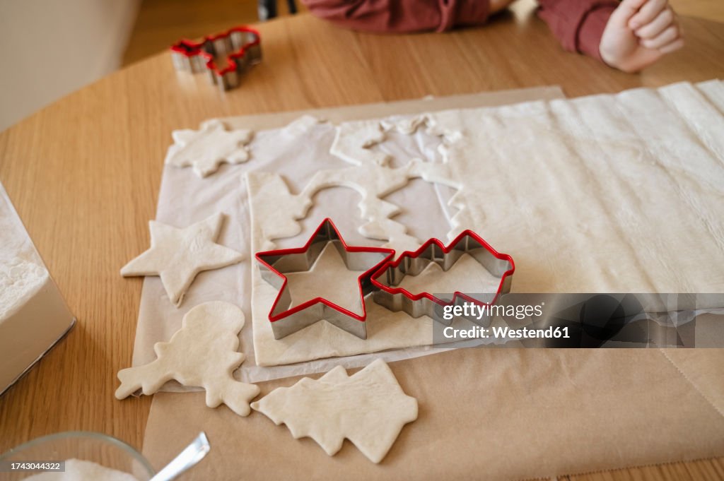 Dough with cookie cutter on table