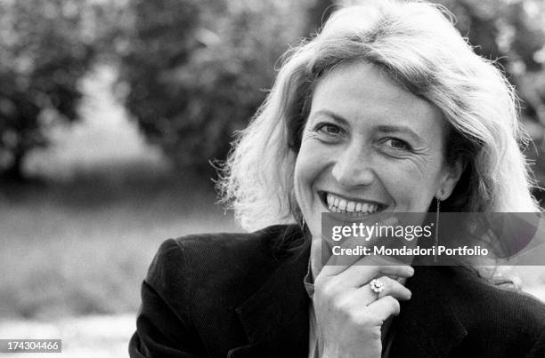 Italian writer and journalist Barbara Alberti smiling with her hand on her chin. 1970s.