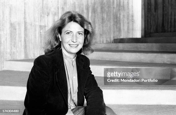 Italian writer and journalist Barbara Alberti smiling sitting on a staircase. 1970s.