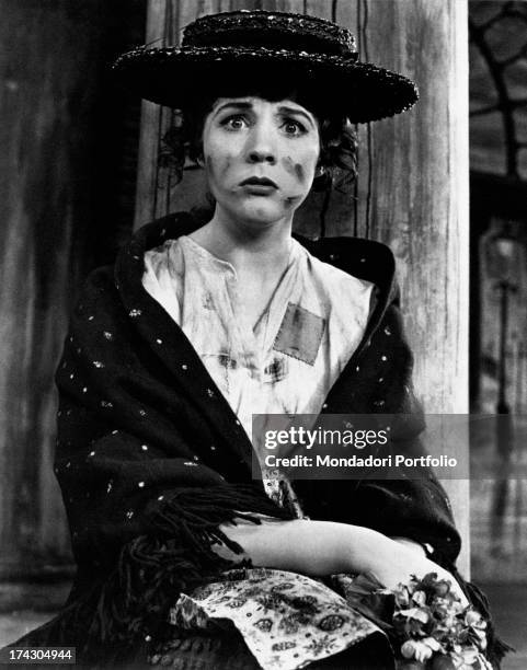 The British actress Julie Andrews, the pseudonym of Julia Elizabeth Wells, wearing a black hat and shall, dirty with soot and with a sullen...