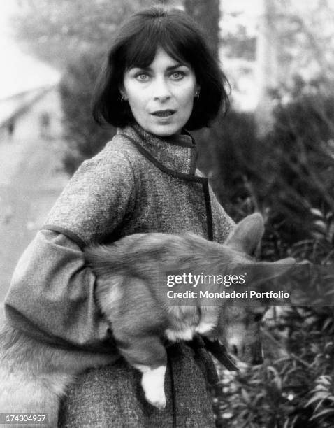 French actress Juliette Mayniel holding a Welsh Corgi dog. Rome, 1970s.