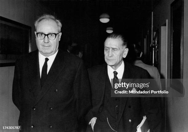 Minister of Foreing Affairs of the Italian Republic Giuseppe Saragat keeping his arms nehind his back and smiling beside a man. Paris, December 1964.