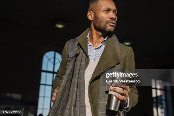 stylish man with reusable cup getting out of the train station - coffee to go cups stock pictures, royalty-free photos & images