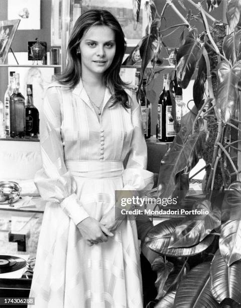 Italian actress Silvia Dionisio posing beside a plant. Rome, 1970s.