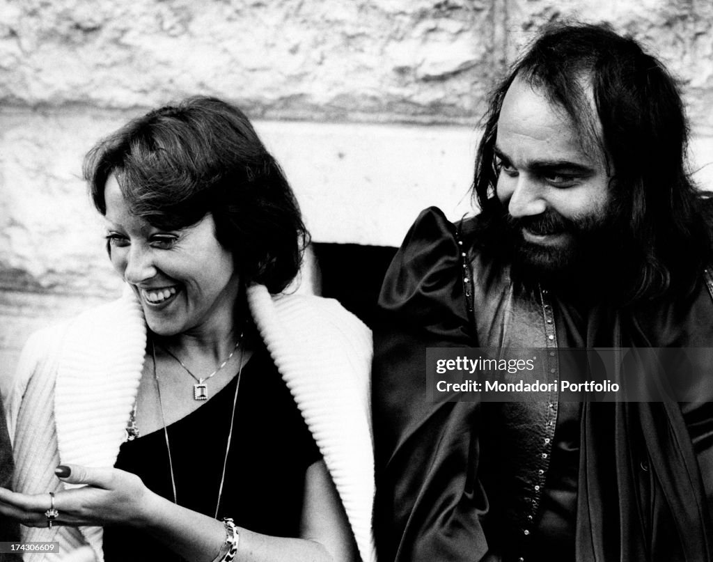 Greek singer and bass player Demis Roussos sitting beside his partner ...