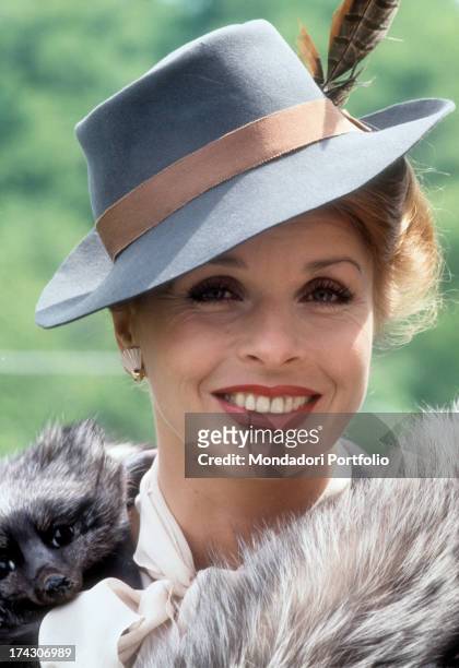 Close-up of the Austrian actress Senta Berger, smiling and wearing a hat with a feather on the set of the tv movie La giacca verde, directed by the...