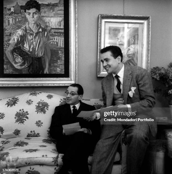 The Italian TV host and anchorman Enzo Tortora, seated on an arm of a sofa, is joking next to the Italian psychoanalyst Emilio Servadio; they are in...