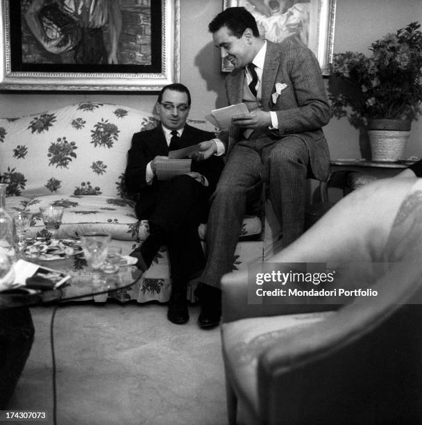 The Italian TV host and anchorman Enzo Tortora, seated on an arm of a sofa, is checking some cards with the Italian psychoanalyst Emilio Servadio;...