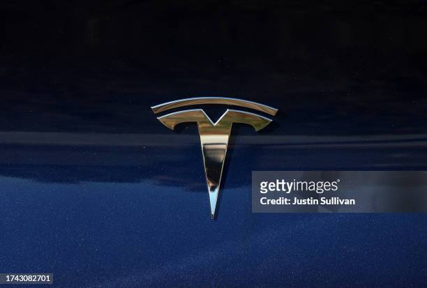The Tesla logo is displayed on a brand new Tesla car at a Tesla dealership on October 18, 2023 in Corte Madera, California. Electric car maker Tesla...