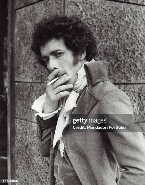 Italian actor Gabriele Lavia smoking on the set of a film. Rome, 1970s.