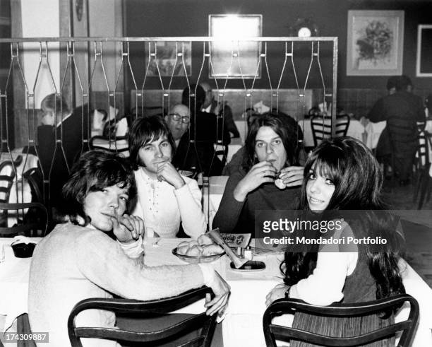 The four members of the Shocking Blue seated together at table in a restaurant, amongst other customers; the Dutch rock band reached number one in...