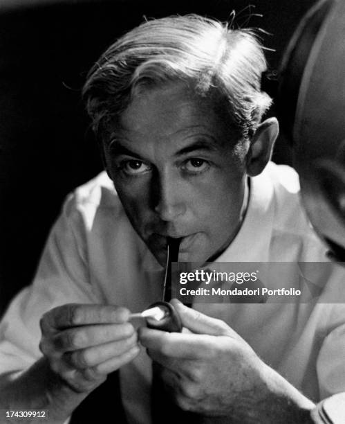 Portrait of the French movie director and screenwriter Robert Bresson, photographed smoking a pipe; former painter prisoner of German war camp during...