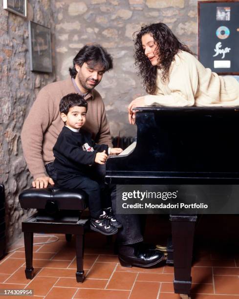 The Italian tenor Andrea Bocelli seated at the piano alongside his two years old son, Amos, in their house in Tuscany, while Bocelli's wife, Enrica...