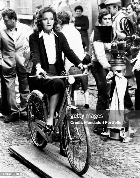 Italian actress Lisa Gastoni riding a bicycle and smoking on the set of Bitter Love. Ferrara, 1974.