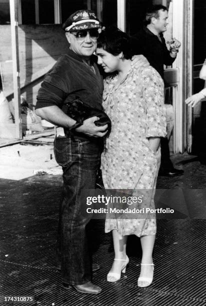 Italian singer and actor Claudio Villa , with a puppy in his arms, hugging his wife Patrizia Baldi. Rome, 1979.