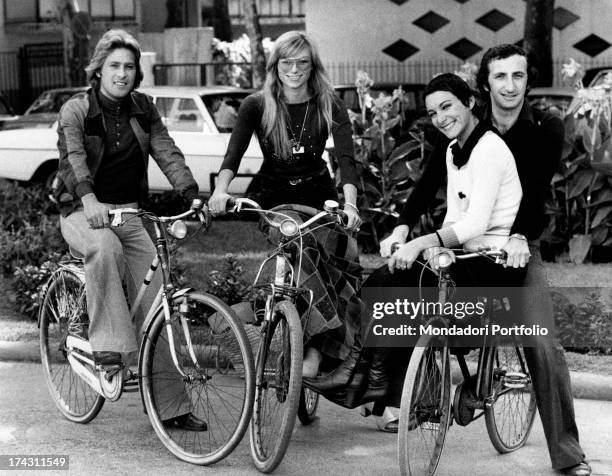 Italian singers Marina Occhiena, Angela Brambati, Angelo Sotgiu and Franco Gatti posing on some bicycles during the International Pop Music Expo....