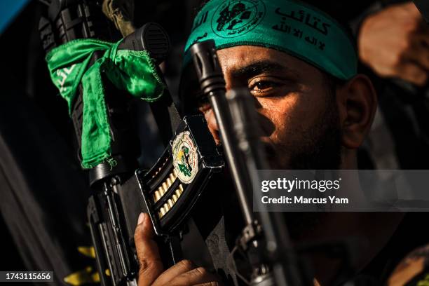 Fighters donning Hamas paraphernalia show support for the Palestinians killed in an Israeli assault on the Nour Shams refugee camp, during a funeral...