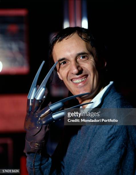 Italian director and scriptwriter Dario Argento smiling and showing the Freddy Krueger's glove with razors inside his shop Profondo Rosso. Freddy...