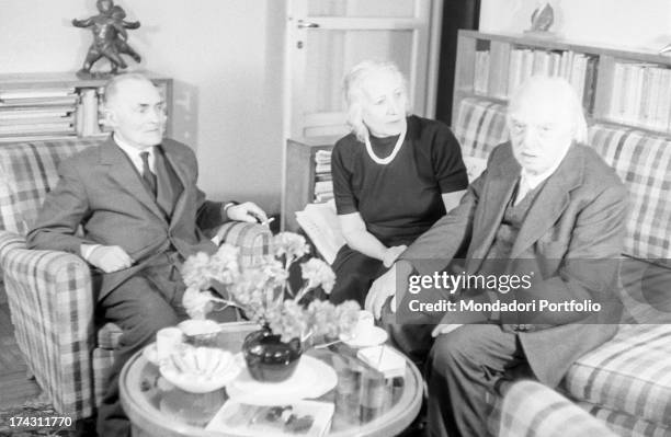 Italian painter Carlo Carrà sitting on the sofa with his wife Ines Minoja and holding a cup. Milan, March 1961.