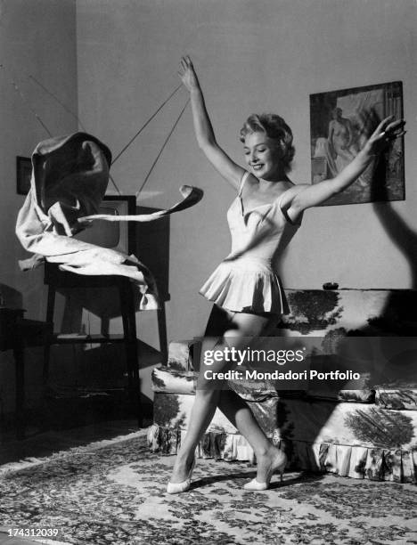 Italian actress and dubber Isa Barzizza in petticoat throwing a jacket. 1950s.