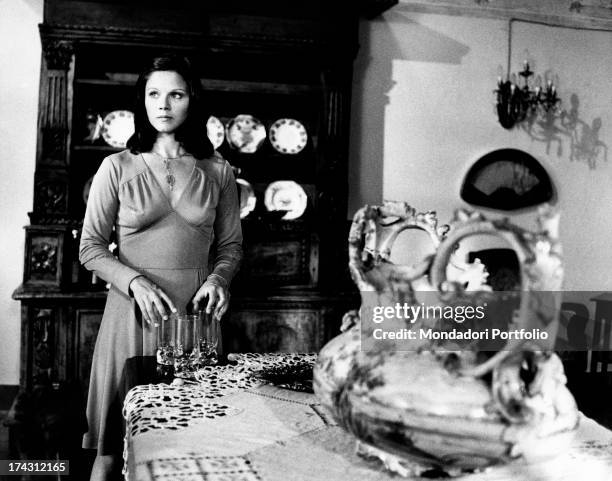 Italian actress Agostina Belli touching some glasses in The Governess. Rome, 1974.