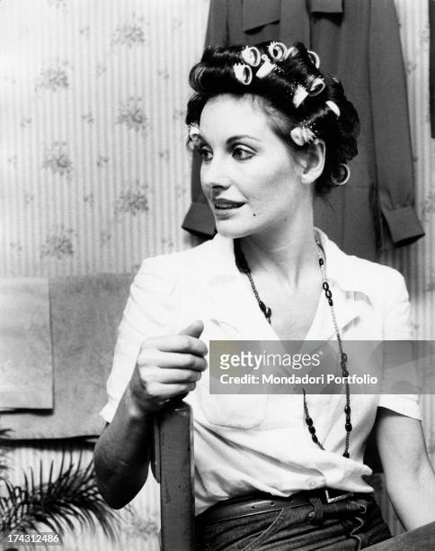 Italian television presenter and actress Gabriella Farinon talking sitting with hair curlers in her hair. Rome, 1970s.