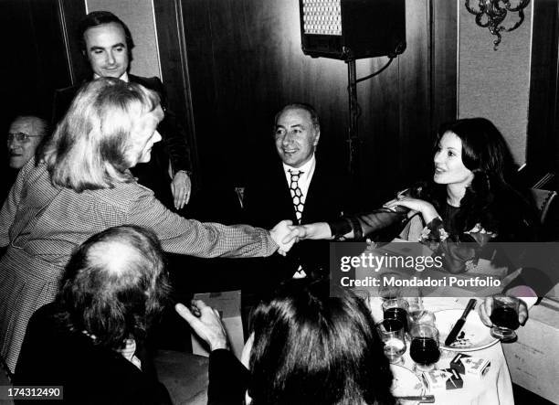 Italian television presenter and actress Gabriella Farinon shaking hands with Italian singer Orietta Berti on the occasion of the singing event...