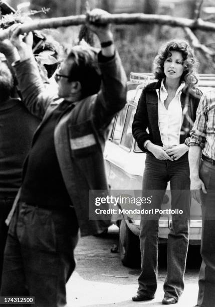 Italian television presenter and actress Gabriella Farinon watching a gardener working. Rome, 1970s.