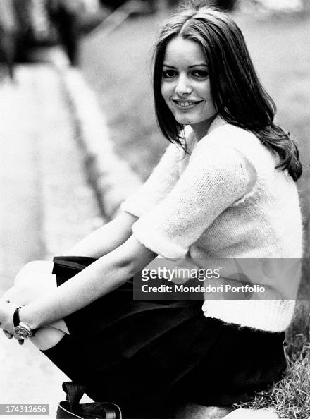 Italian singer Nada sitting on the edge of a flowerbed and smiling ...