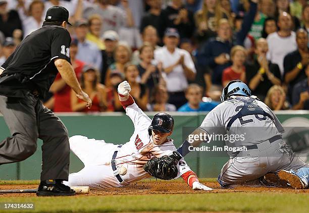 Jose Molina of the Tampa Bay Rays drops the ball as Stephen Drew of the Boston Red Sox scores in the 8th inning at Fenway Park on July 23, 2013 in...