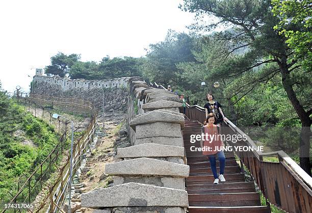 NKorea-SKorea-anniversary-war-history-raid, FEATURE by Giles Hewitt This picture taken on June 28, 2013 shows visitors hiking a path alongside the...