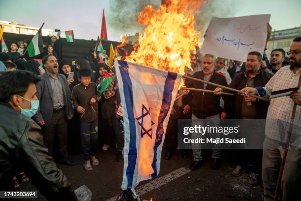 Iranian protestors set fire to the American and Israeli flags as they take part in a protest in support of Palestinians in Gaza at the...