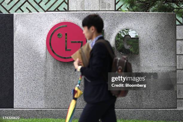 Man walks past signage for the LG Twin Towers, which houses LG Corp. Subsidiaries including LG Electronics Inc., LG Display Co., LG Chem Ltd. And LG...