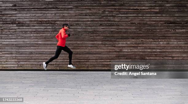 middle aged male athlete leaping against lumber wall - placecompetes stock pictures, royalty-free photos & images