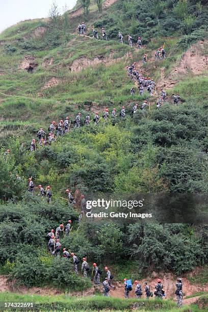 Rescuers head to the site of a mudslide at Tongxin village on July 23, 2013 in Minxian, China. At least 95 people were killed and more than 1,000...