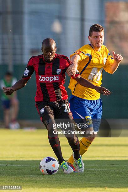 Youssee Mulumbu of West Bromwich Albion challenges Smrekar Matija of Puskas FC Academy during the pre season friendly match between Puskas FC Academy...