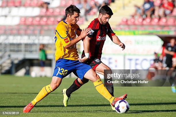 Shane Long of West Bromwich Albion challenges Norbert Farkas of Puskas FC Academy during the pre season friendly match between Puskas FC Academy and...