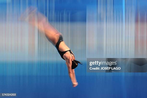 In a picture taken with a slow shutter speed Romania's Mara Elena Aiacoboae competes in the women's 10-metre platform preliminary diving event in the...