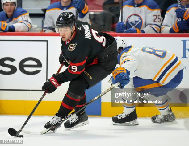 Josh Norris of the Ottawa Senators controls the puck against Alex Tuch of the Buffalo Sabres at Canadian Tire Centre on October 24, 2023 in Ottawa,...
