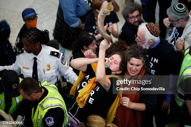 Woman blows a ram's horn shofar as U.S. Capitol Police arrest demonstrators as they rally to demand a cease-fire against Palestinians in Gaza in the...