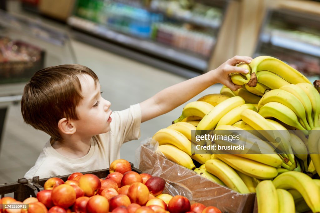 Menino de 6 anos fazendo compras em um supermercado