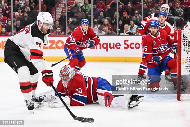 Dougie Hamilton of the New Jersey Devils skates the puck around goaltender Cayden Primeau of the Montreal Canadiens during the first period at the...