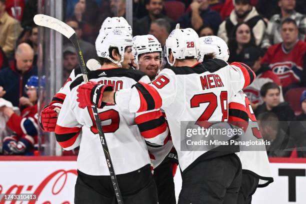 Alexander Holtz of the New Jersey Devils celebrates his goal with teammates John Marino and Timo Meier during the first period against the Montreal...