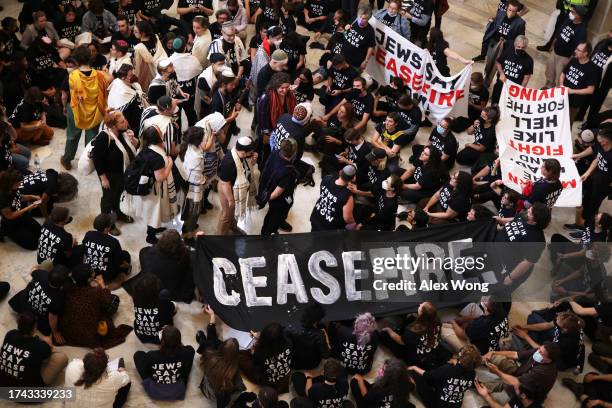 Protesters stage a demonstration in support of a cease fire against the Palestinians in Gaza in the Cannon House Office Building on October 18, 2023...